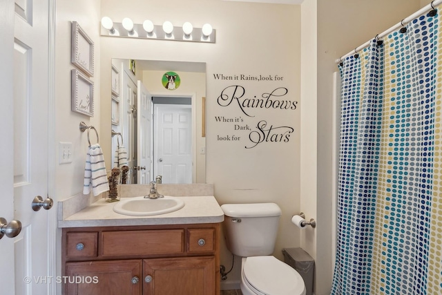 bathroom with toilet, vanity, and a shower with curtain