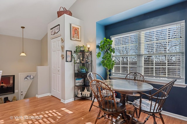 dining space featuring hardwood / wood-style floors and lofted ceiling