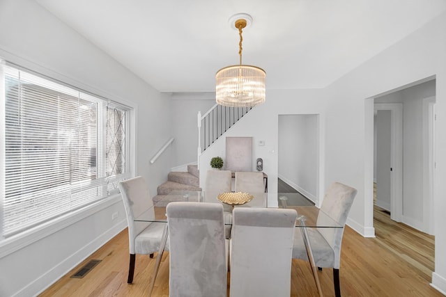 dining area featuring light hardwood / wood-style flooring and an inviting chandelier