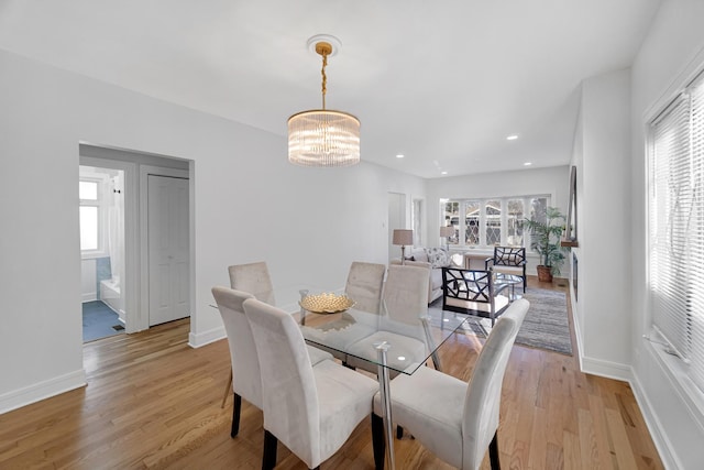 dining space with a chandelier and light hardwood / wood-style flooring