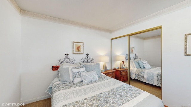 carpeted bedroom with a closet and ornamental molding