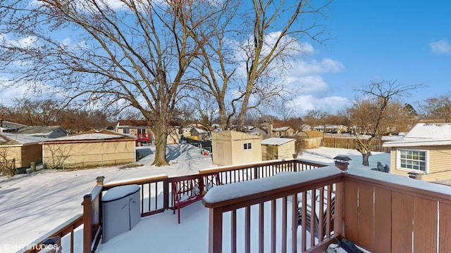 snow covered deck featuring a shed