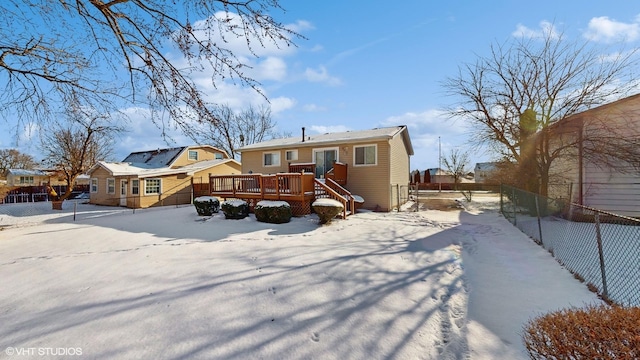 snow covered rear of property featuring a deck