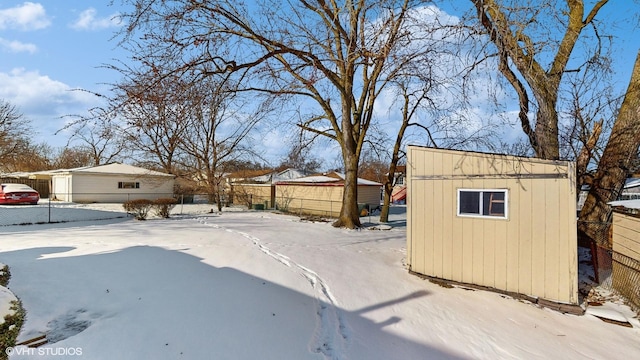 snowy yard with a storage shed