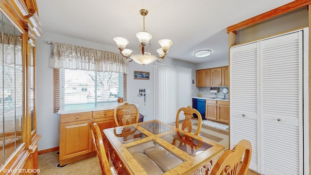 dining room featuring light carpet, an inviting chandelier, and sink