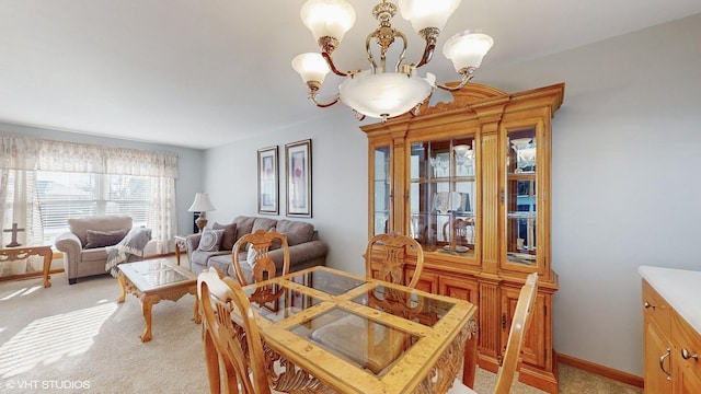 carpeted dining area with a chandelier