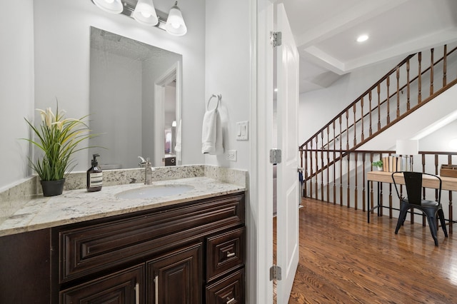 bathroom with hardwood / wood-style flooring, beamed ceiling, and vanity