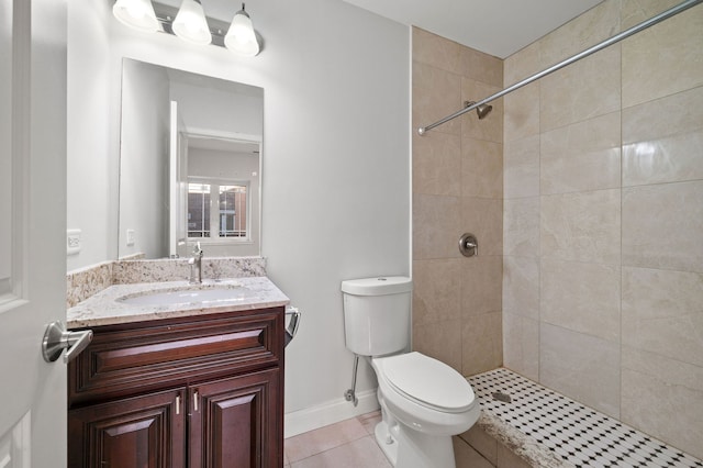 bathroom with tile patterned floors, toilet, vanity, and tiled shower