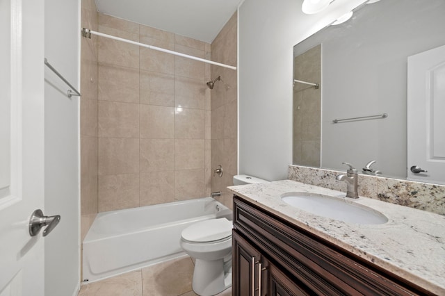 full bathroom with toilet, tiled shower / bath, tile patterned floors, and vanity