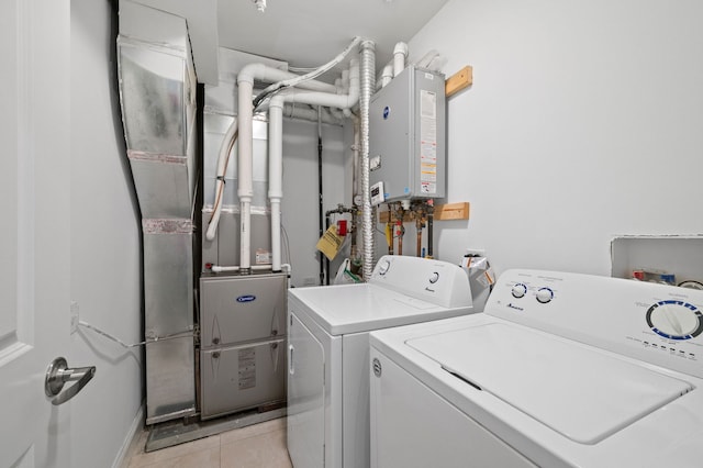 laundry room featuring washer and clothes dryer, light tile patterned floors, and water heater