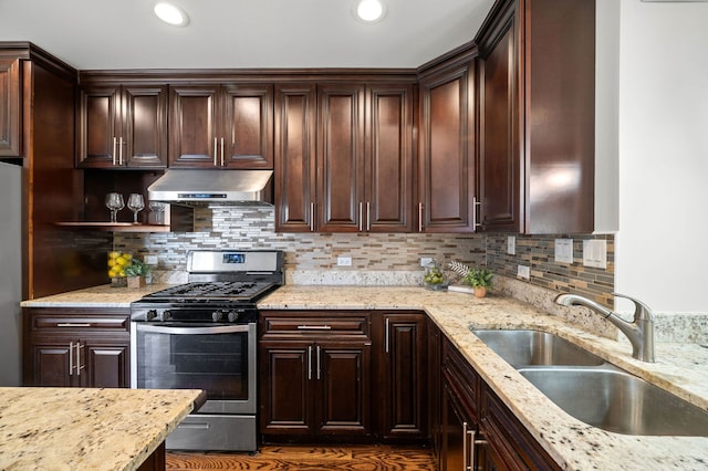 kitchen with sink, light stone countertops, and stainless steel gas range