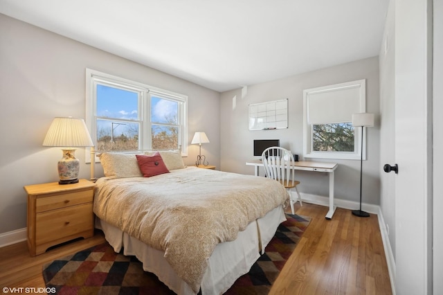 bedroom featuring multiple windows and hardwood / wood-style floors