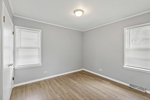 unfurnished room with a healthy amount of sunlight, light hardwood / wood-style floors, and crown molding