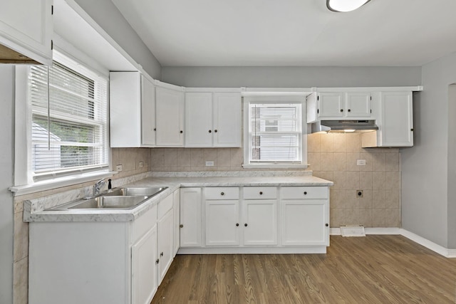 kitchen with dark hardwood / wood-style floors, white cabinetry, sink, and a wealth of natural light