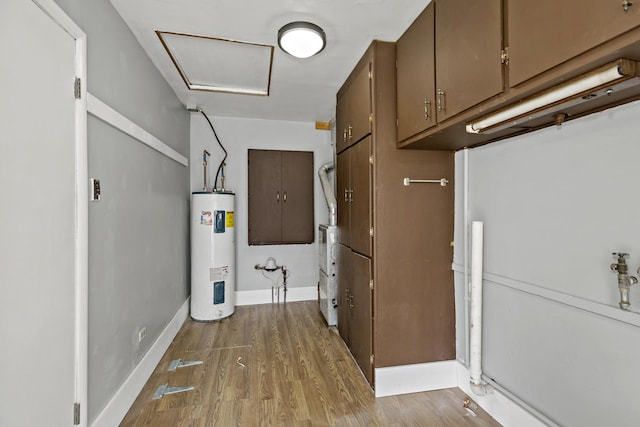 washroom with electric water heater, cabinets, and wood-type flooring