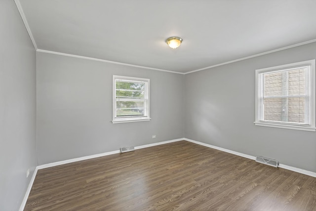 empty room featuring dark hardwood / wood-style flooring and ornamental molding