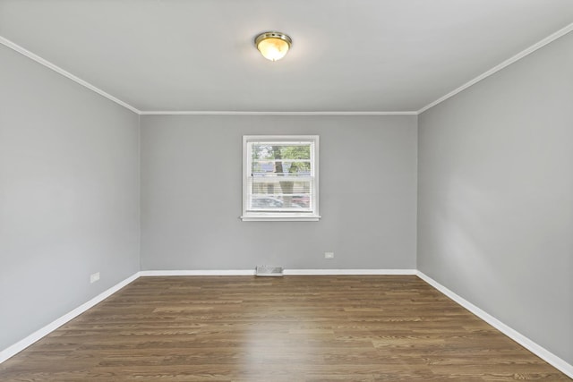 spare room featuring dark hardwood / wood-style floors and crown molding