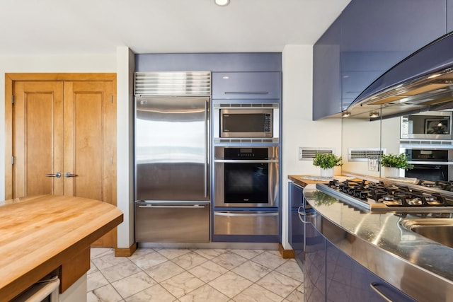 kitchen with dark stone counters and appliances with stainless steel finishes