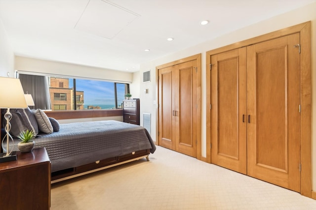 carpeted bedroom featuring multiple closets