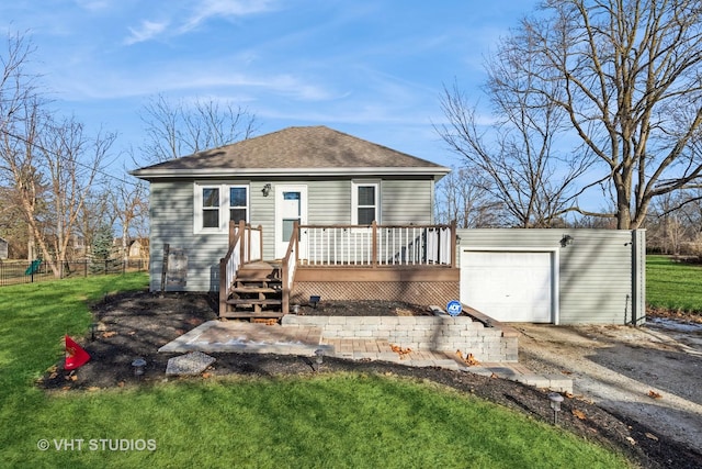 view of front of house featuring an outbuilding, a front lawn, a deck, and a garage