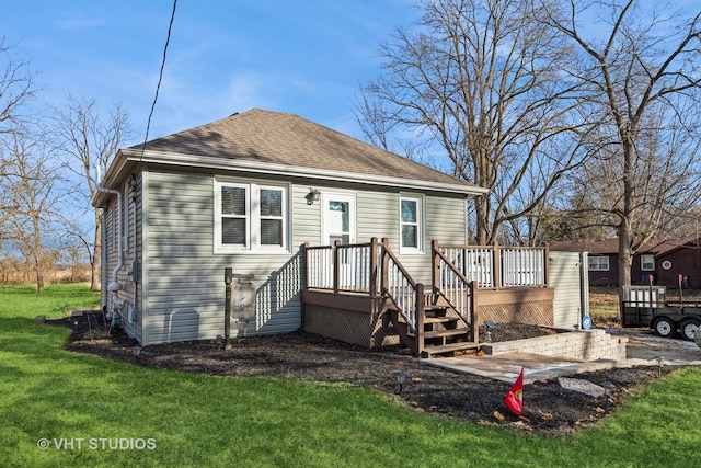 view of front of home featuring a garage, an outdoor structure, a front yard, and a deck