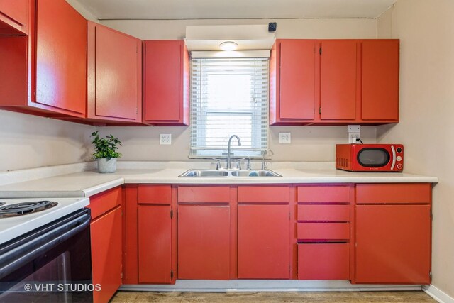 kitchen featuring pendant lighting, light hardwood / wood-style floors, sink, and white range with electric stovetop