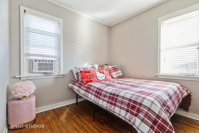 bedroom with dark wood-type flooring, crown molding, and cooling unit