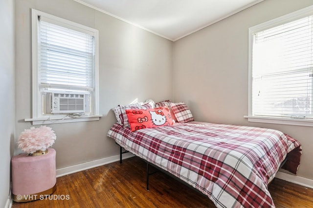 bedroom with dark wood-type flooring, ornamental molding, and cooling unit