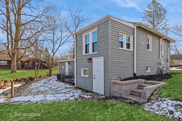 view of snow covered exterior with a lawn