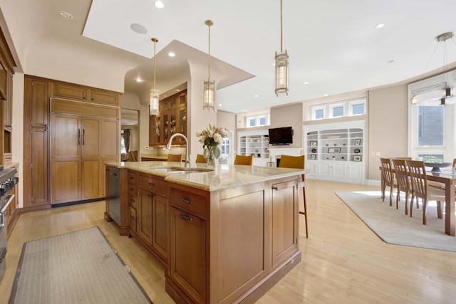 kitchen with built in shelves, a spacious island, sink, and hanging light fixtures