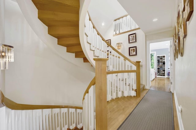 stairway with a towering ceiling and hardwood / wood-style flooring