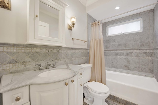 full bathroom with shower / bath combo, vanity, toilet, and tile walls