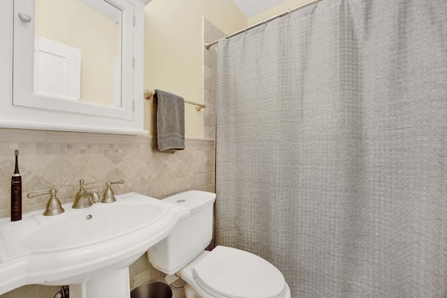 bathroom with a shower with curtain, sink, and toilet