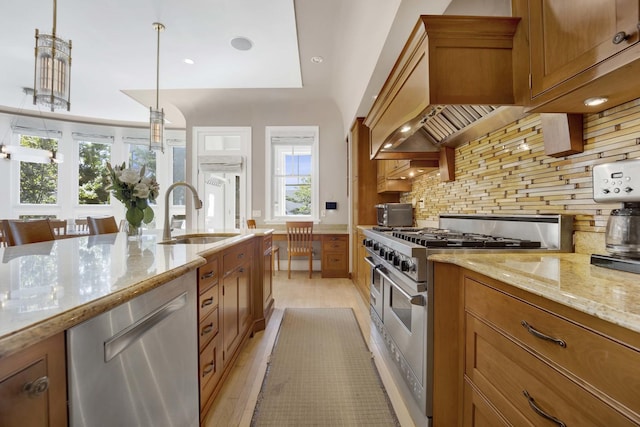 kitchen with backsplash, sink, hanging light fixtures, light stone counters, and stainless steel appliances