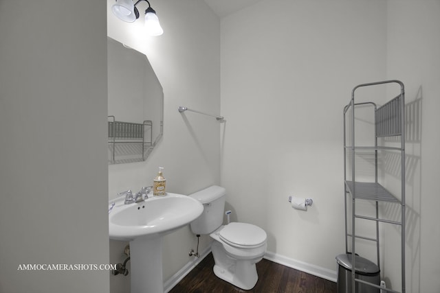 bathroom featuring wood-type flooring, toilet, and sink