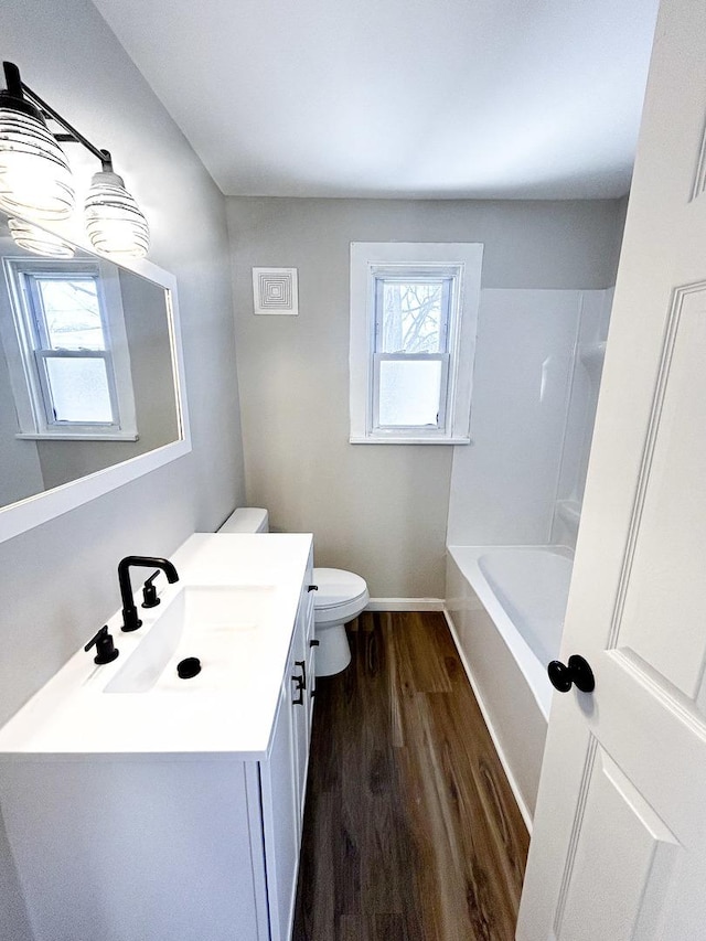 bathroom with toilet, vanity, and hardwood / wood-style floors