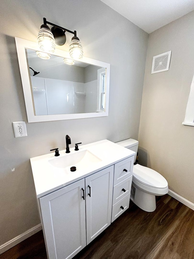 bathroom featuring toilet, a shower, wood-type flooring, and vanity