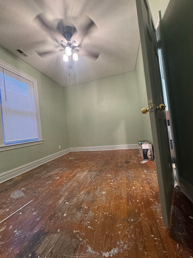 spare room featuring ceiling fan and dark wood-type flooring