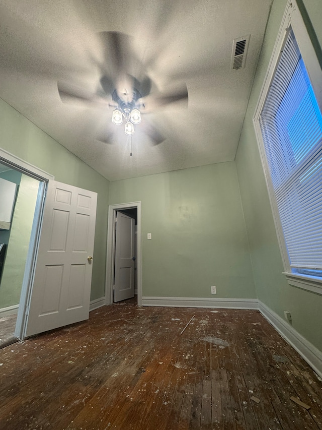 unfurnished bedroom featuring lofted ceiling, a textured ceiling, ceiling fan, and dark wood-type flooring