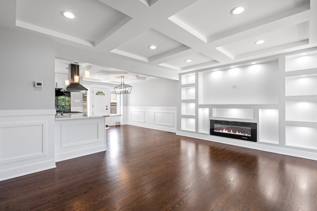 unfurnished living room with dark hardwood / wood-style flooring, built in features, a chandelier, and coffered ceiling