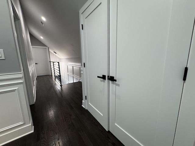 hallway featuring dark hardwood / wood-style floors and vaulted ceiling