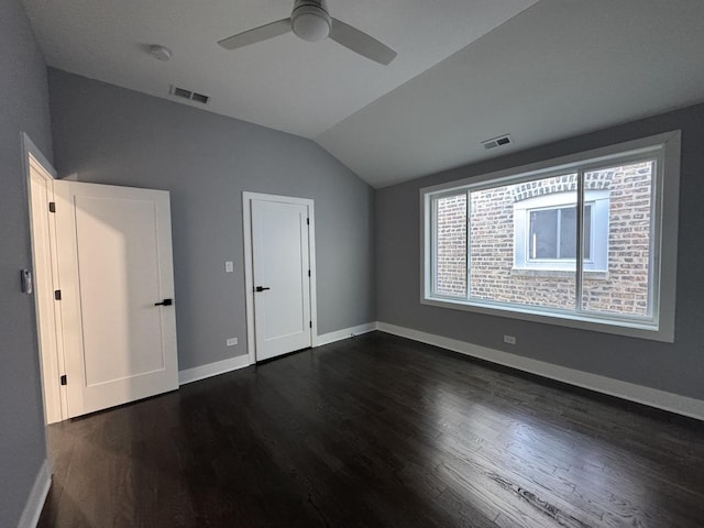 unfurnished bedroom featuring dark hardwood / wood-style flooring, vaulted ceiling, and ceiling fan