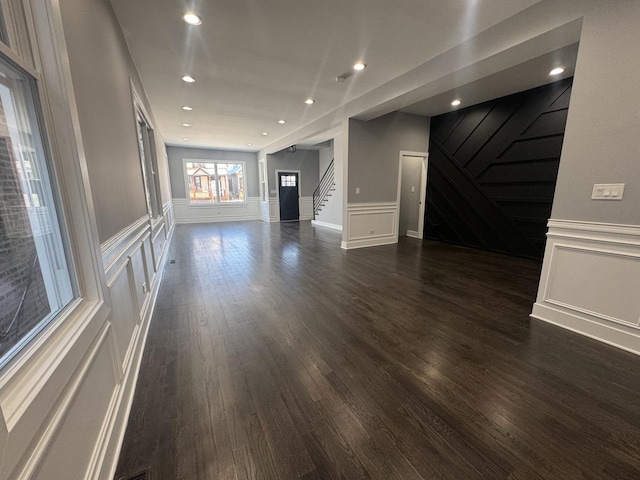 unfurnished living room with dark wood-type flooring