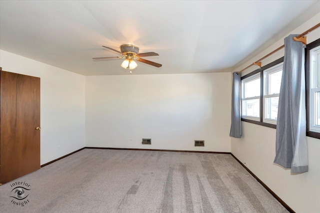 spare room with ceiling fan and light colored carpet