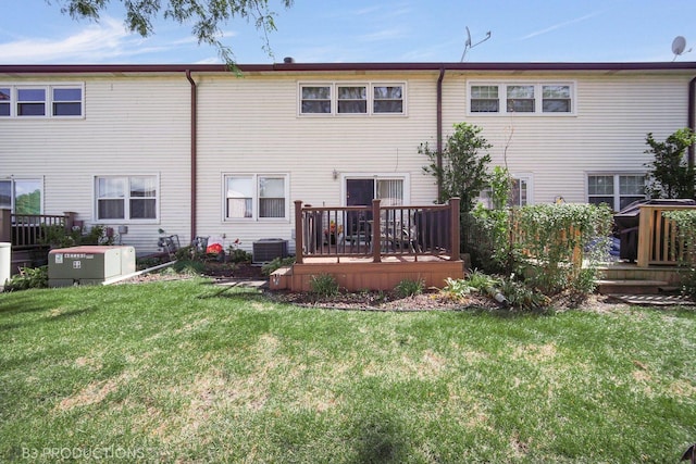 back of property featuring central air condition unit, a deck, and a lawn