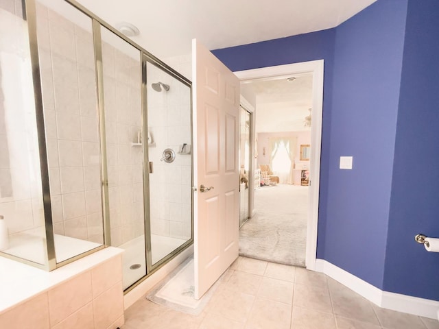 bathroom featuring a shower with door, ceiling fan, and tile patterned floors