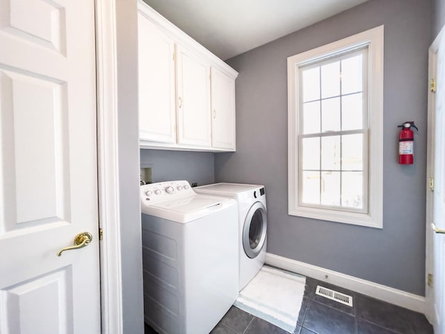 washroom featuring dark tile patterned floors, separate washer and dryer, and cabinets