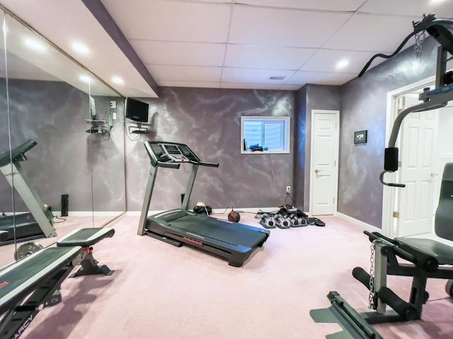 exercise room featuring a paneled ceiling and carpet flooring