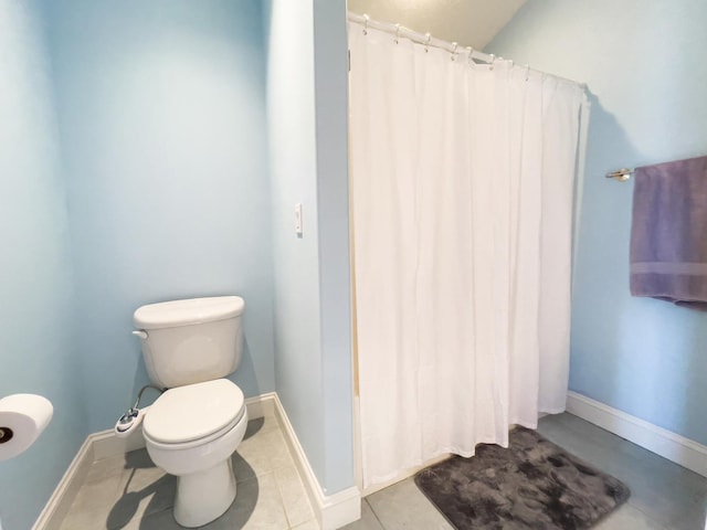 bathroom with a shower with shower curtain, tile patterned flooring, and toilet