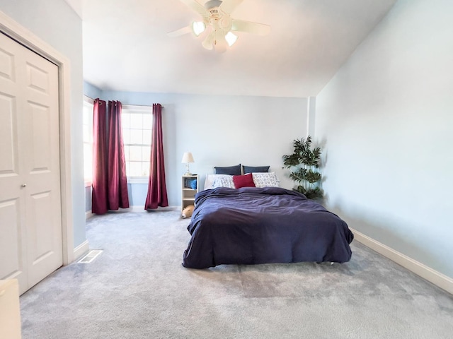 carpeted bedroom with ceiling fan and a closet